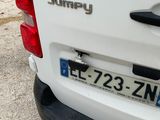 the rear end of a white van parked on the side of the road