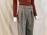 an image of a mannequin wearing a brown sweater and grey pants