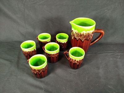 five cups and a pitcher sitting on a table