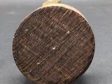 a close up of a wooden knob on a gray surface