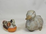deux figurines de canards assis l'un à côté de l'autre