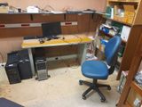 a computer desk with a blue chair next to a bookshelf