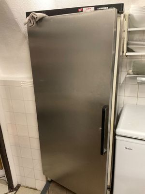 a stainless steel refrigerator in a kitchen with a washer and dryer