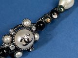 a black and white beaded bracelet with pearls on a blue background