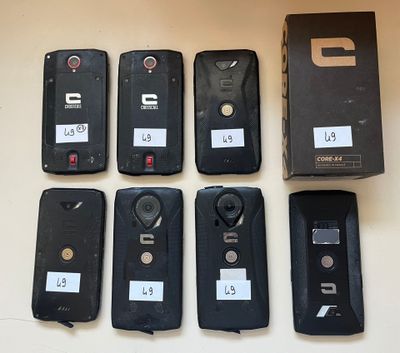 Plusieurs téléphones portables sont alignés sur une table, à côté d'une boîte