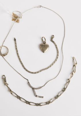un assortiment de bijoux en argent comprenant un pendentif en forme de cœur, une chaîne et une paire de boucles d'oreilles