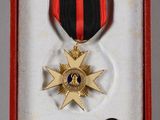 a medal in a red box with a black and red ribbon