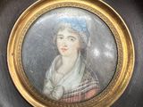 painting of a woman with a blue flower in her hair in a gold frame