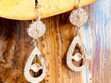 une paire de boucles d'oreilles posée sur un morceau de bois