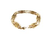 gros plan d'un bracelet en or sur fond blanc