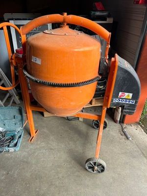 une bétonnière orange posée sur un chariot dans un garage