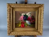 a picture of a painting of flowers in a vase on a easel