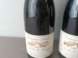two bottles of wine sitting next to each other on a table