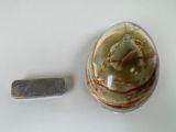 a small piece of silver next to a marble