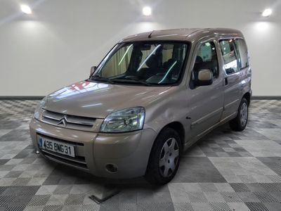 une photo d'une petite camionnette argentée garée dans un garage
