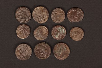 a close up of a bunch of coins on a black surface