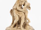 a statue of a woman holding a child on top of a wooden base