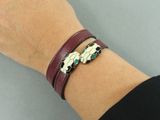 quelqu'un porte un bracelet orné d'une tête de mort et d'une croix