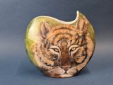une pomme en forme de tigre sur laquelle est dessiné un visage