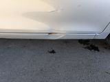 a white car that has a hole in the side of it