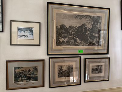 many framed pictures on the wall of this room