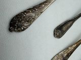 four spoons and two spoon spoons on a white surface