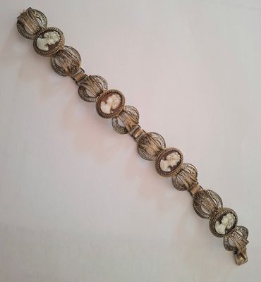 a close up of a metal bracelet with a clock on it