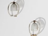 une paire de boucles d'oreilles en argent et en or posées sur une surface blanche