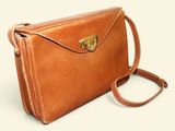 brown leather handbag on a white background with a brown strap