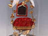 a glass clochet with a red velvet cushion under it