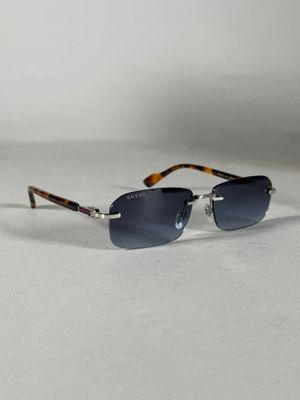 une paire de lunettes de soleil posée sur une surface blanche