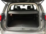 the back of a silver car with its trunk open showing the cargo area