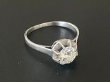 une photo d'une bague en diamant posée sur une surface noire