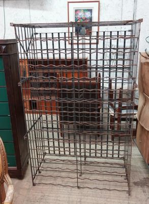 une grande cage métallique contenant tout un tas de bouteilles