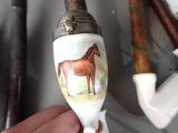a person holding a pipe holder with a horse on it