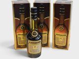 trois bouteilles de whisky posées les unes à côté des autres sur une surface blanche