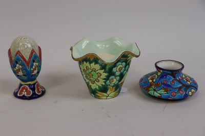 trois vases de couleurs différentes posés les uns à côté des autres sur une surface blanche