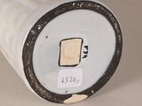 a close up of a white vase with a tag on it