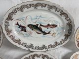 five plates with fish painted on them on a table