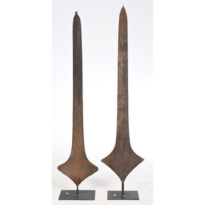 a pair of old iron swords on stands on a white background