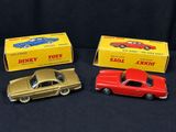 trois petites voitures Dinky Toys sont alignées les unes à côté des autres