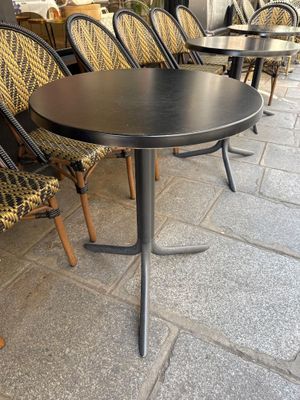 Des tables et des chaises sont alignées à l'extérieur d'un restaurant