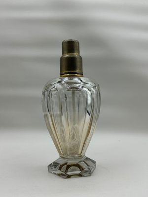 une image représentant une bouteille en verre transparent avec un bouchon doré