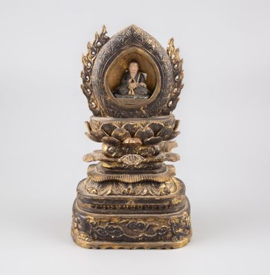 une statue en or représentant un Bouddha assis sur une fleur de lotus