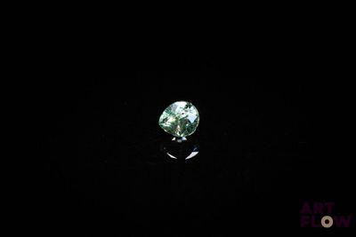 gros plan d'un diamant vert sur une surface noire