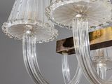 a chandelier made of glass and wood with a white shade