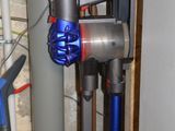 une image représentant un aspirateur bleu et argenté dans une pièce