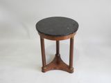 une table avec un plateau en marbre noir, des pieds en bois et un piètement en bois