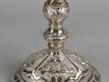 an antique silver plated candle holder with a candle on top of it