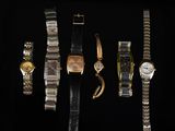 un ensemble de cinq montres différentes sur un fond noir